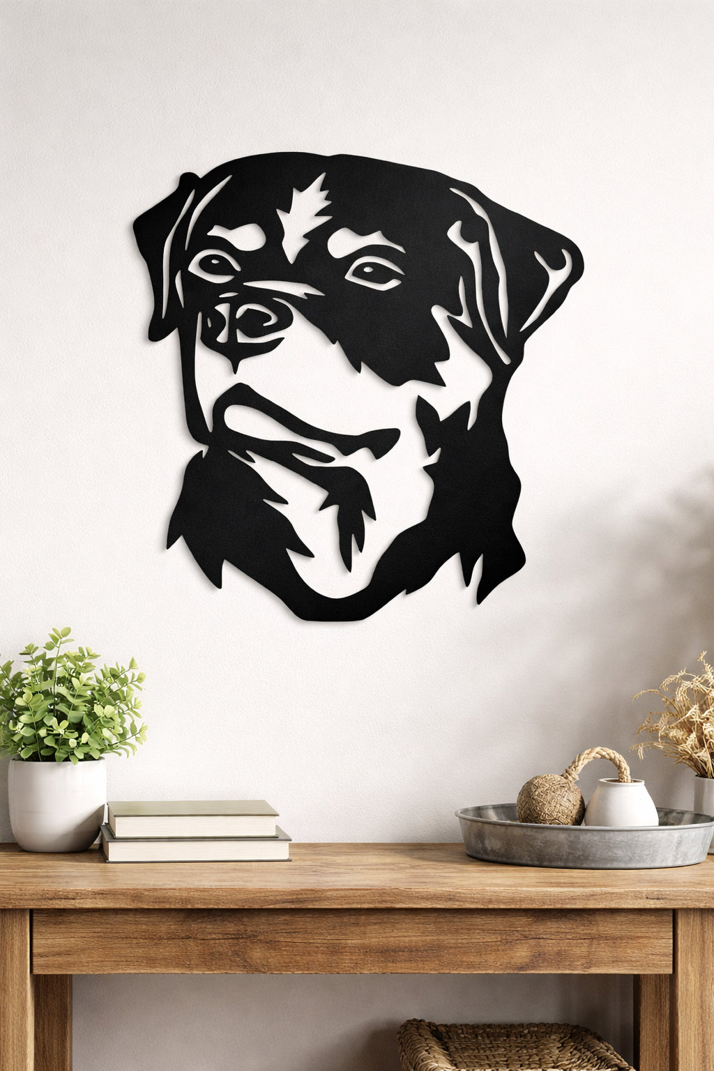 Black dog-shaped wall art on a white wall above a wooden table.